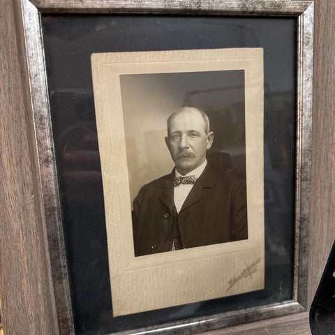 Late 19th century portrait of mustached man on bow tie in wood and silver gilt frame.