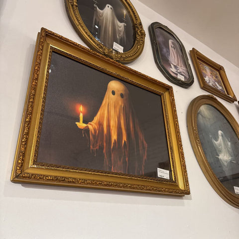 Ghost holding candle in gold frame