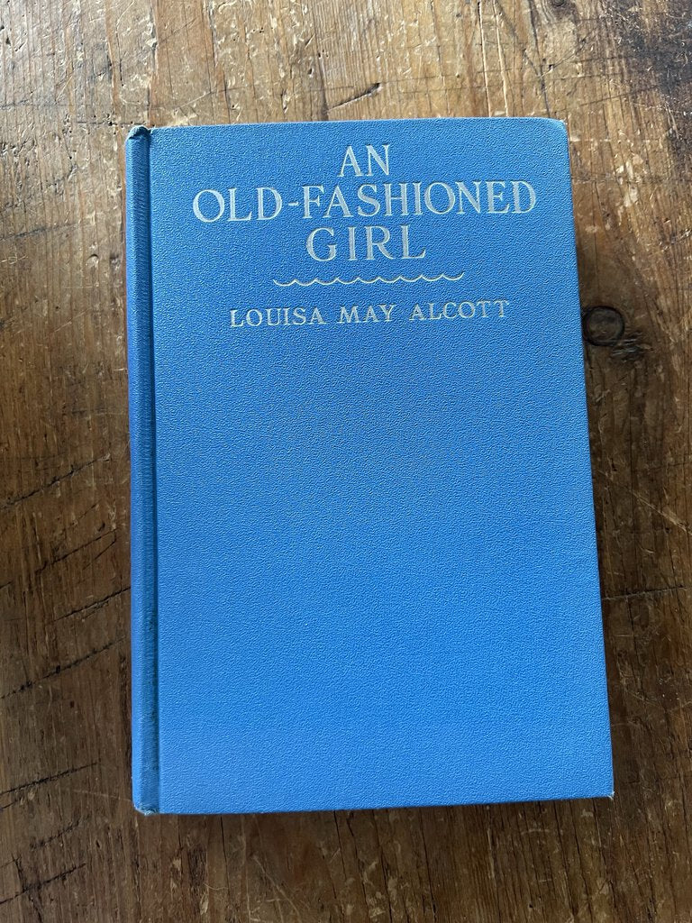 Blue covered book, An Old Fashioned Girl, by Louisa May Alcott